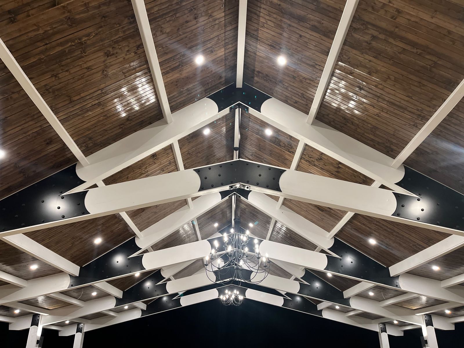 Vaulted ceiling with white beams and chandelier