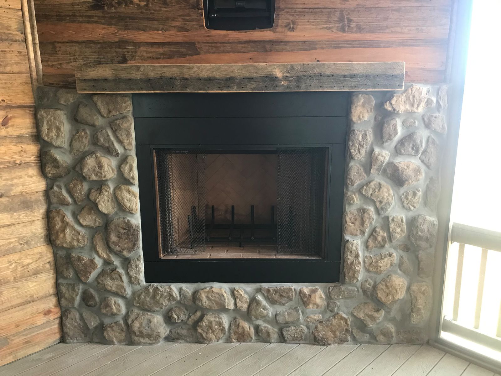 Stone fireplace with reclaimed wood mantel