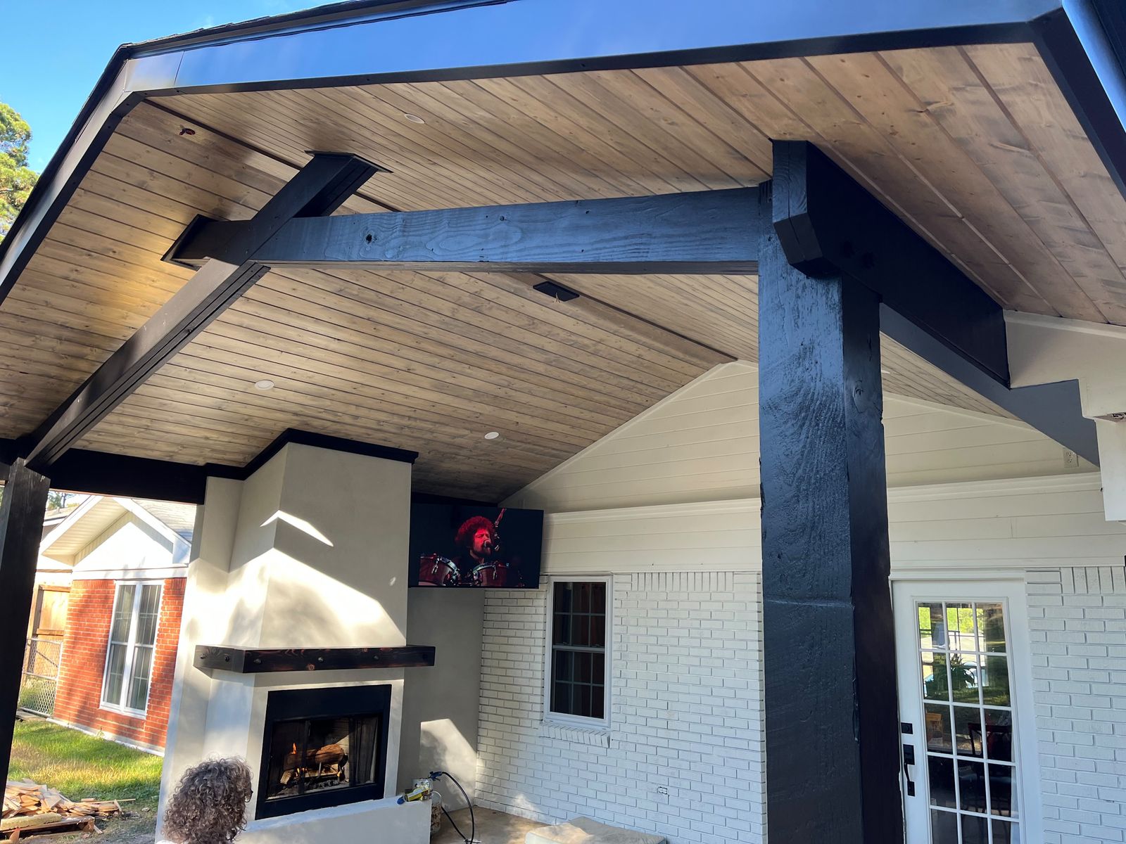 Outdoor fireplace under a cedar ceiling