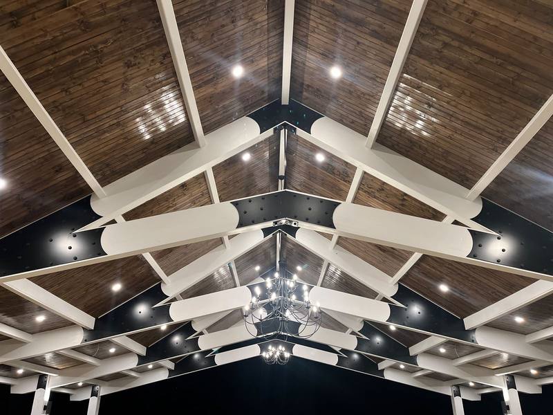 Vaulted ceiling with white beams and chandelier