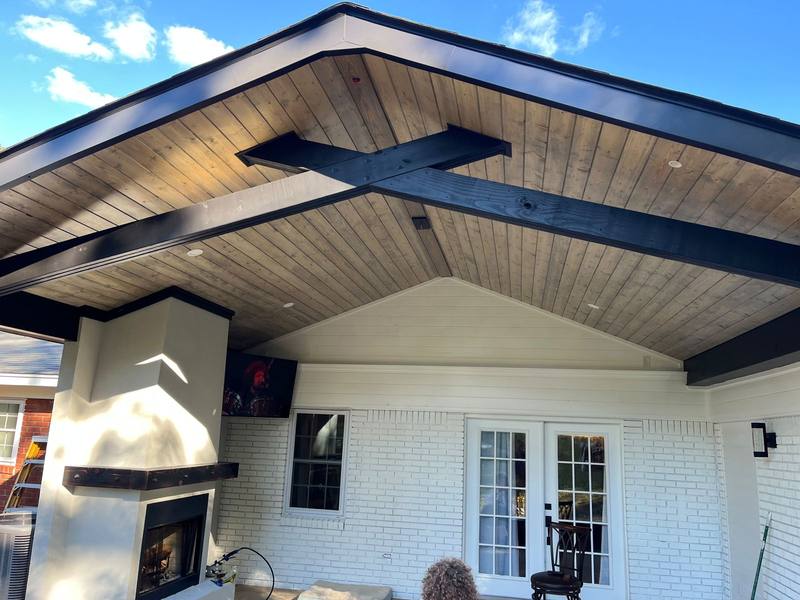 Covered patio with fireplace and black beams